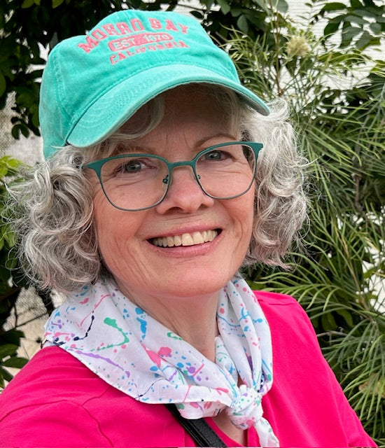 Teresa O’Shaughnessy smiling outdoors in a green cap. Representative portrait, not a photograph from the March 9, 2026 Austin Organic Gardeners event.