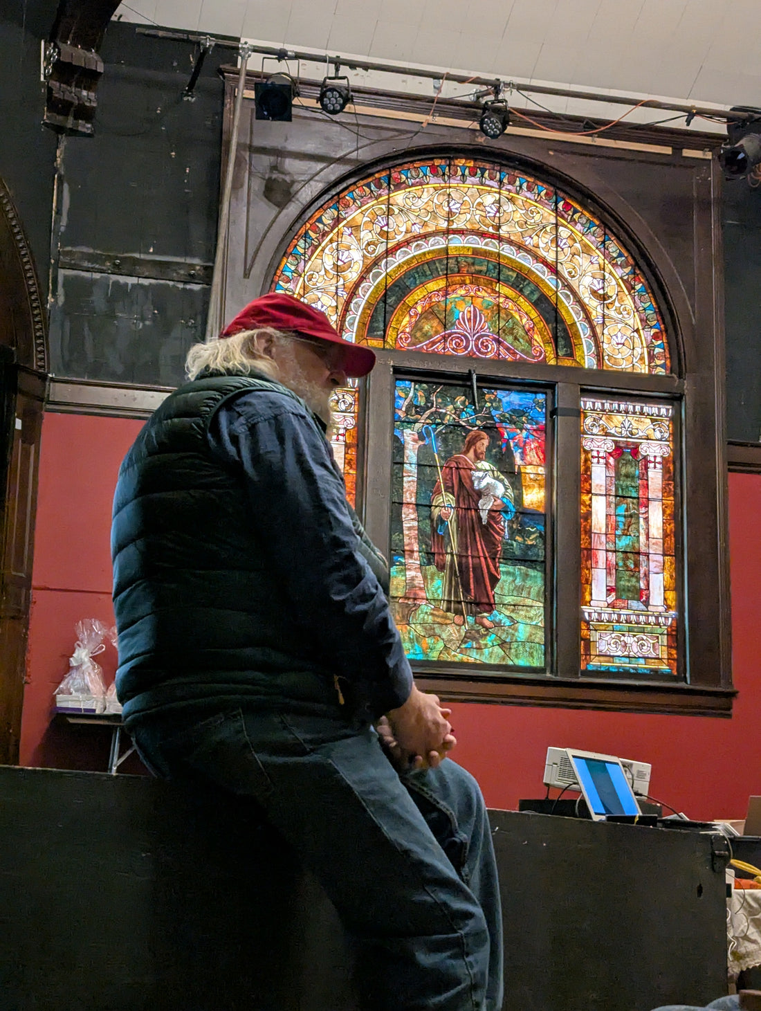 An attendee standing before a stained-glass window at the 2025 Fellowship of Preparation Makers gathering