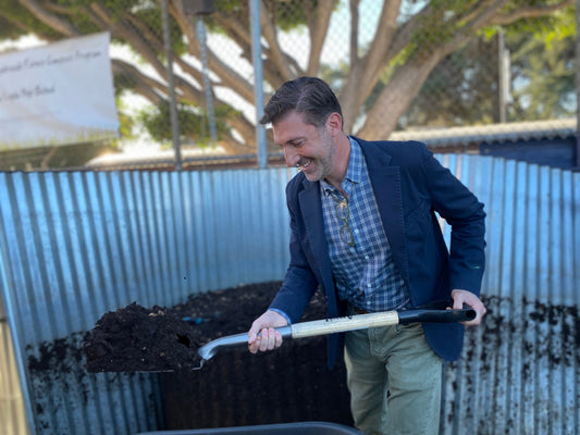 A school administrator participating in the compost harvest at a Wynbrandt Farms school compost program