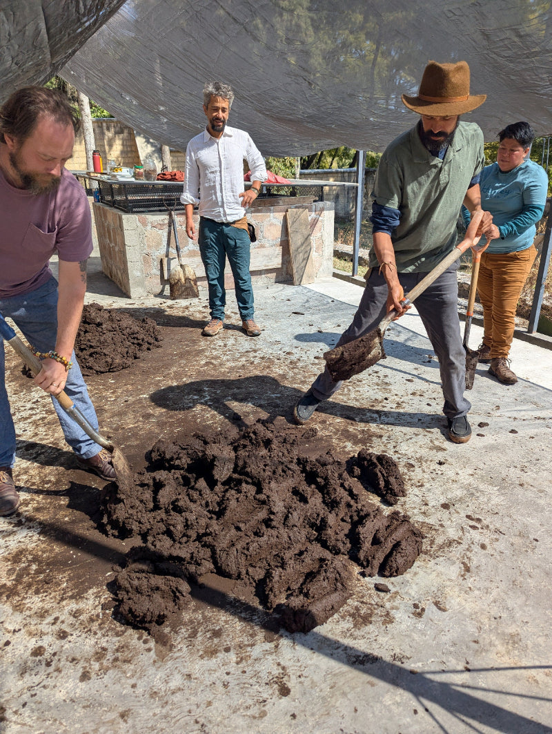 Four men working with manure making biodynamic barrel compound
